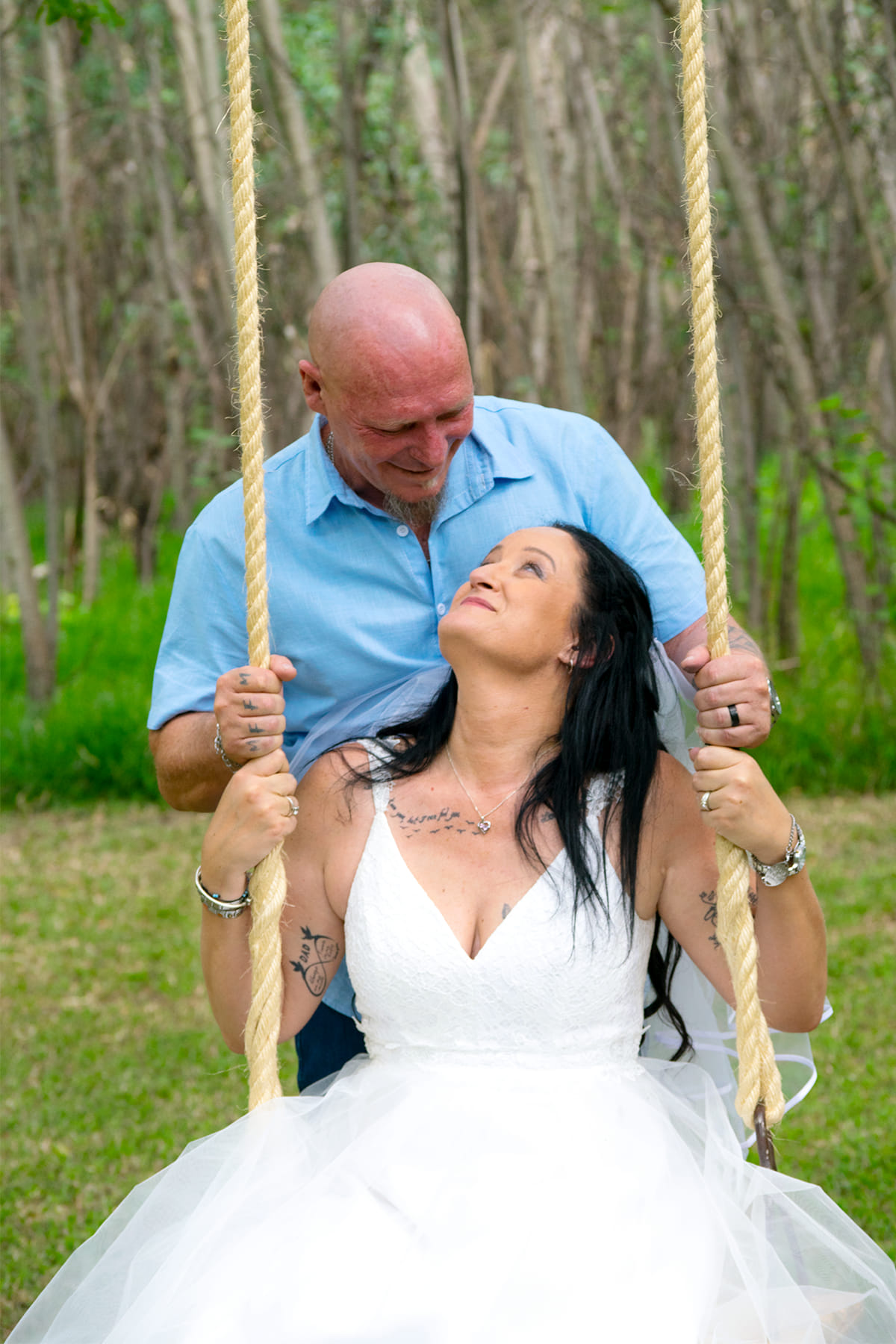 Wedding couple posing on a garden swing.